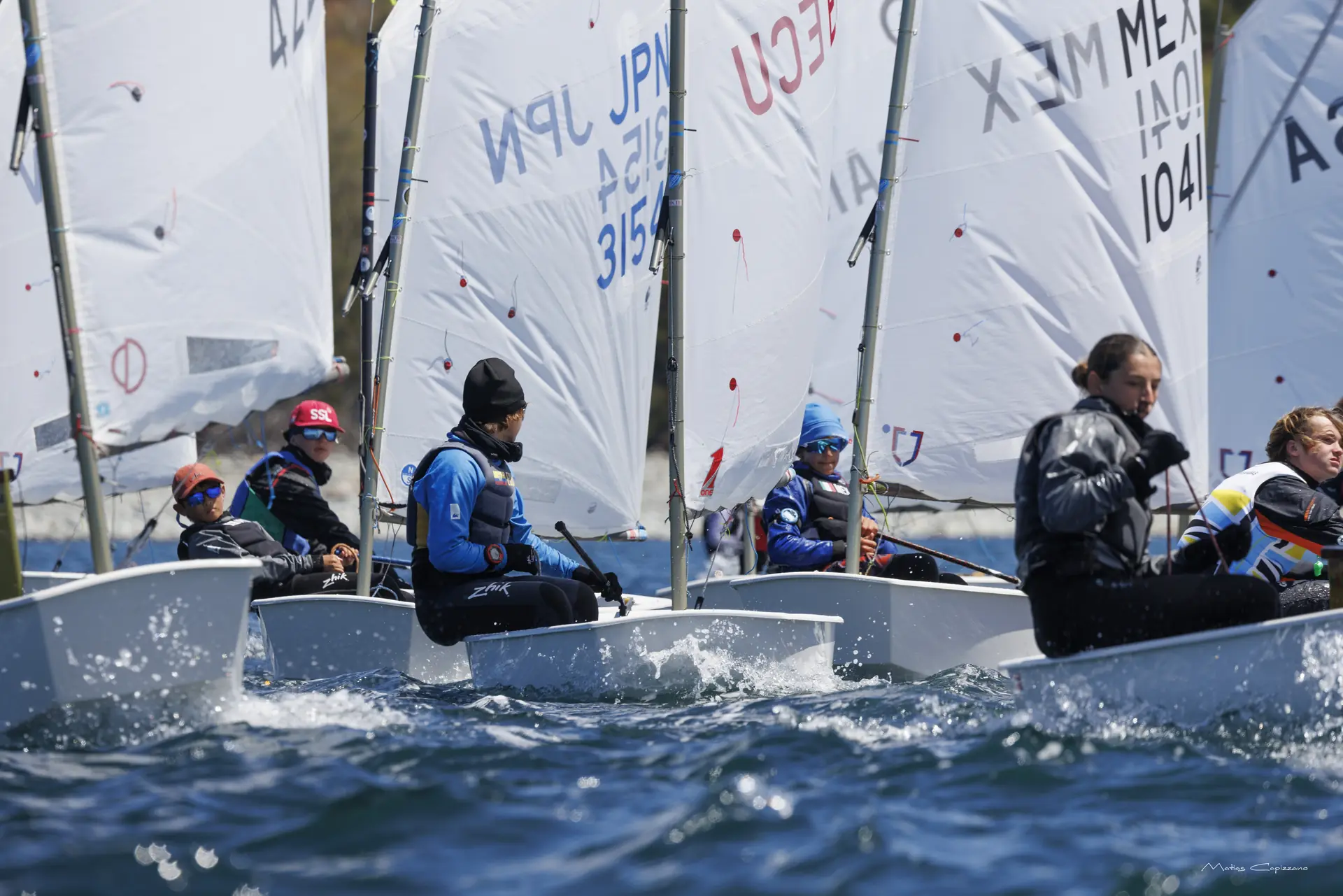 Flota de Optimist en regata con velas de Ecuador, Japón y México durante el Campeonato Norteamericano 2026 en Halifax, Canadá.